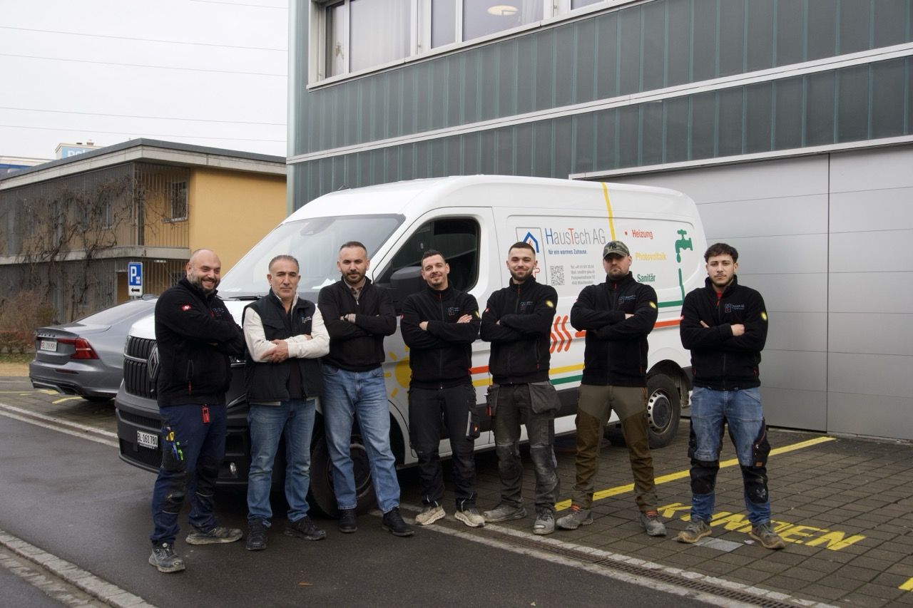 Das Team von HausTech Plus vor den Firmenfahrzeugen